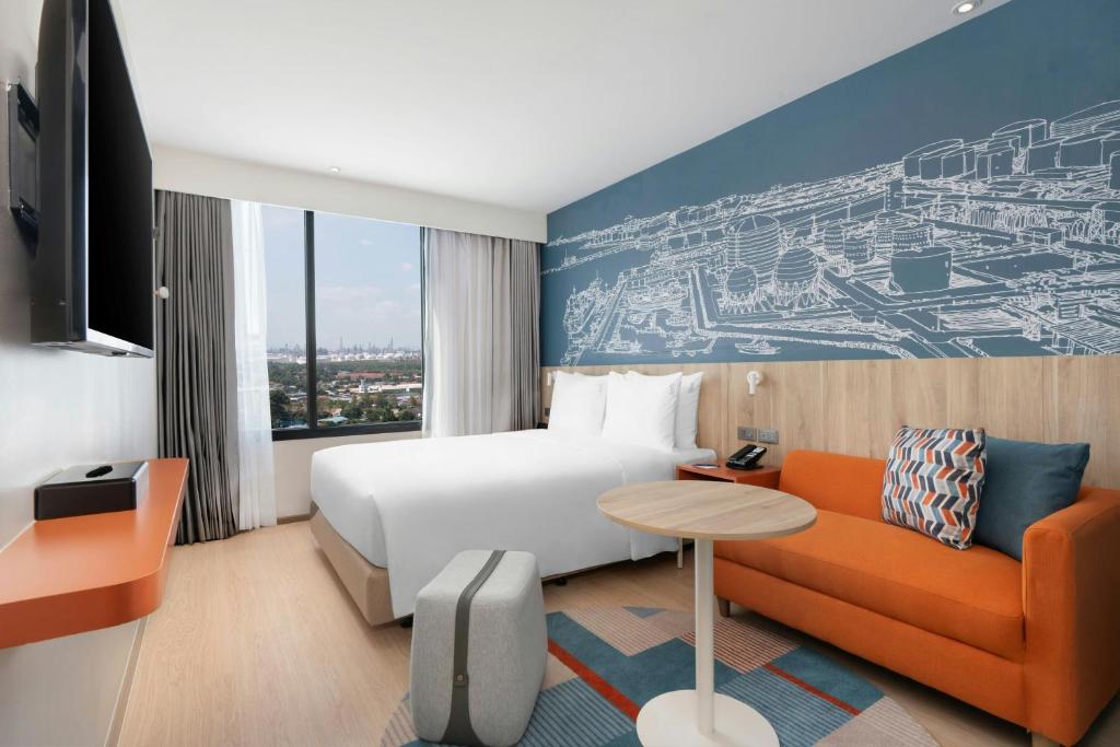 a hotel room with a bed and a couch at Holiday Inn Express Rayong in Rayong