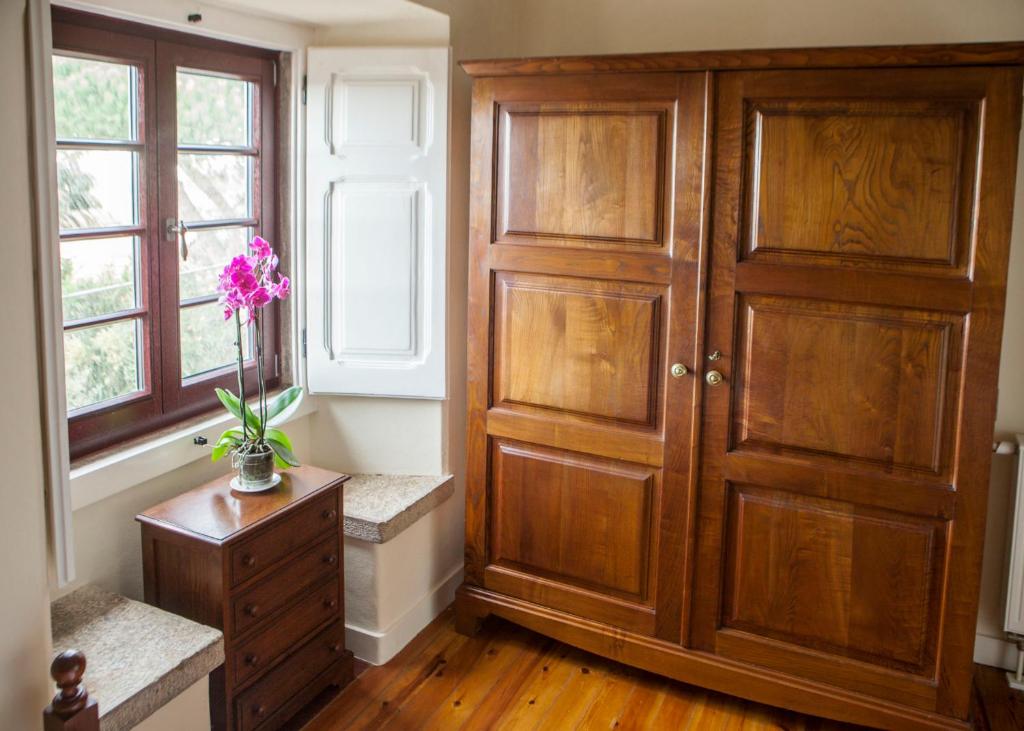 a room with a wooden door and a vase with purple flowers at Quinta Santo António in Sintra
