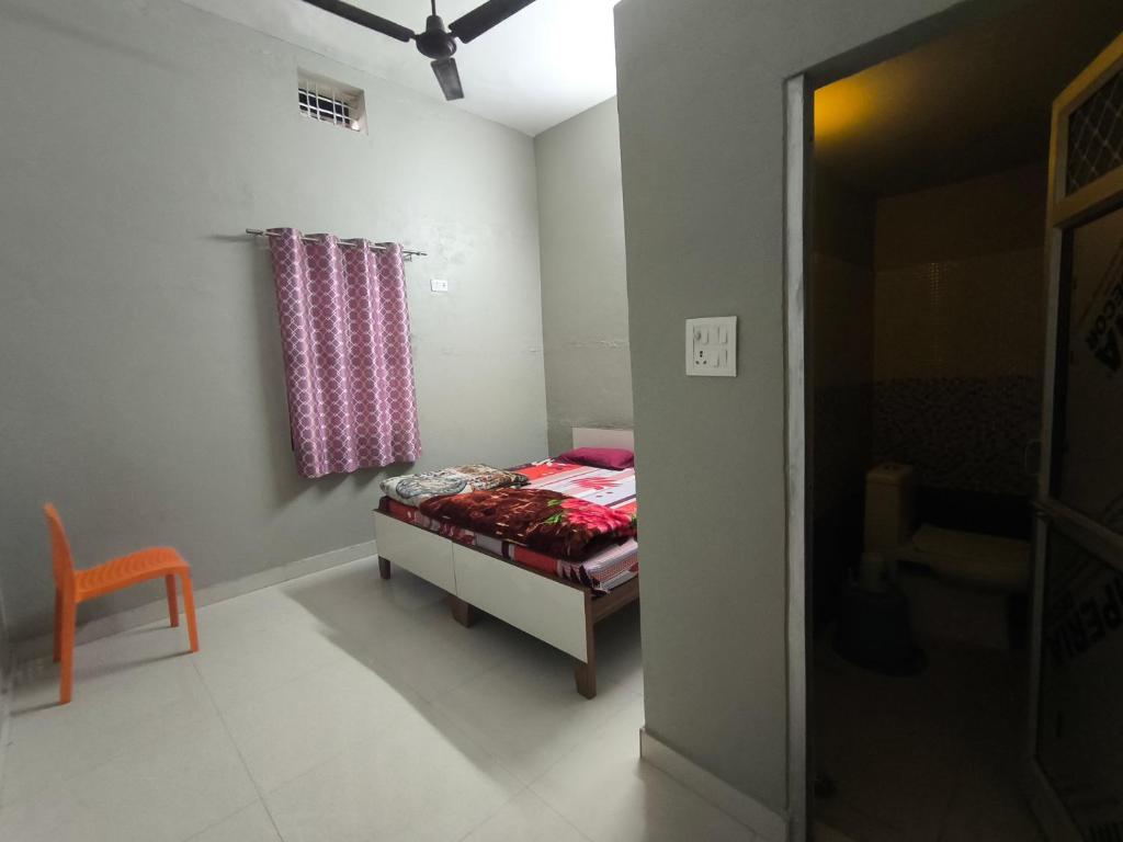 a small bedroom with a bed and a window at Vivek Hotel in Banbāsa