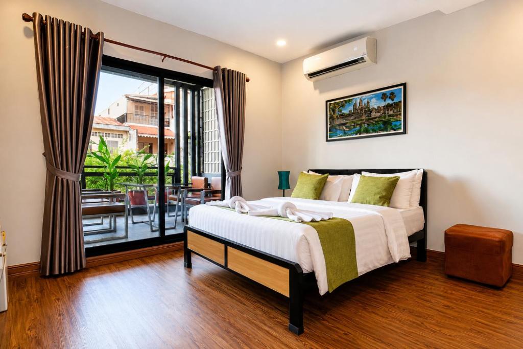 a bedroom with a large bed and a balcony at Ostro Hotel in Phnom Penh