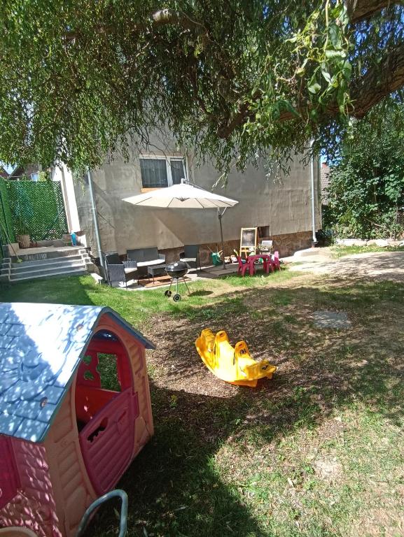 a dog house and an umbrella in a yard at Apartmán Slepička in Weissbach