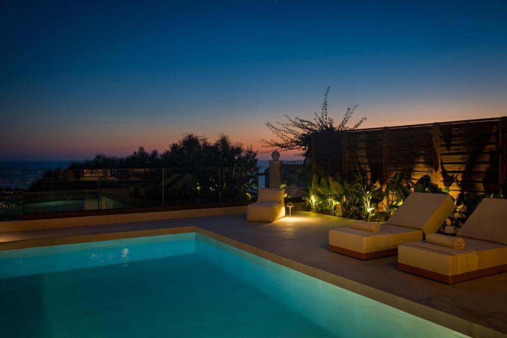 a swimming pool with two lounge chairs at Don Gerassimo in Argostoli