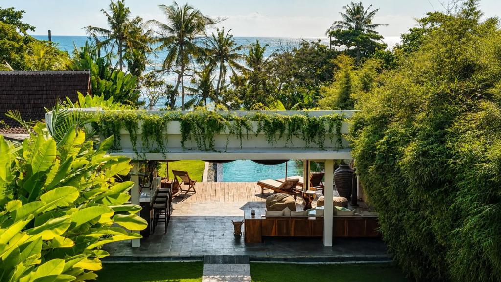 a house with a view of a garden at Private beach Oceanfront 3bd Villa in Cemagi