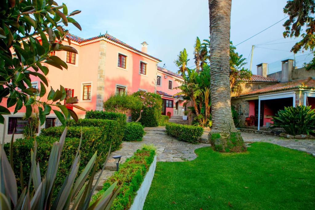 un patio con una palmera y una casa en Quinta Santo António en Sintra