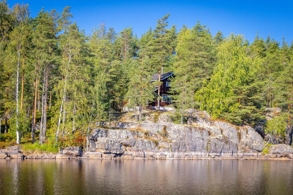 a tree house on a rock by the water at Mökki Kalliola in Puumala