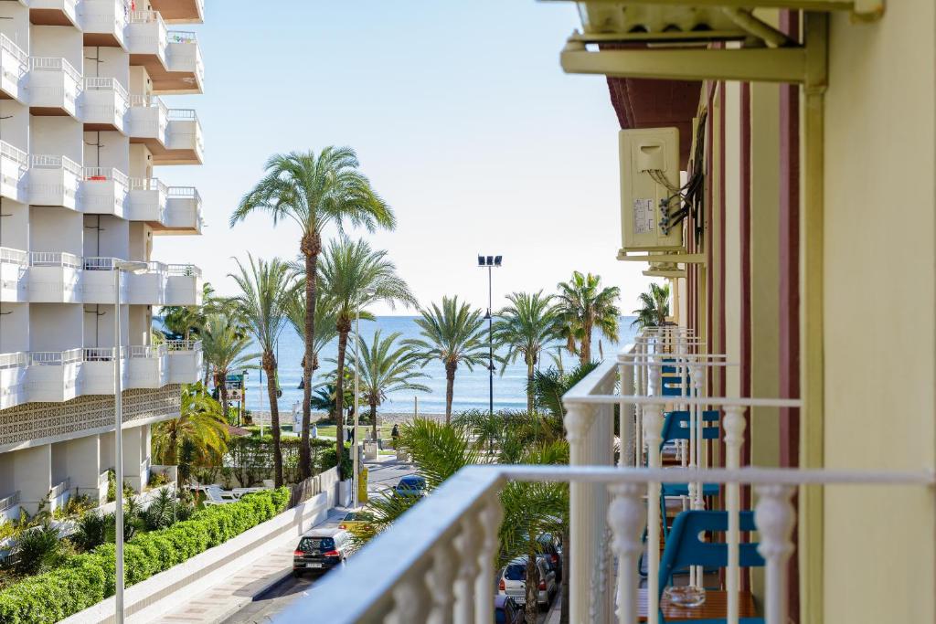 balcón con vistas al océano y a las palmeras en Candisol Cozy Inns, en Torremolinos