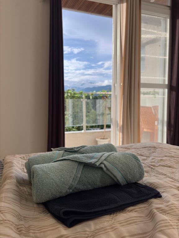 a bed with two pillows on it with a window at The Green Hush in Rājpur