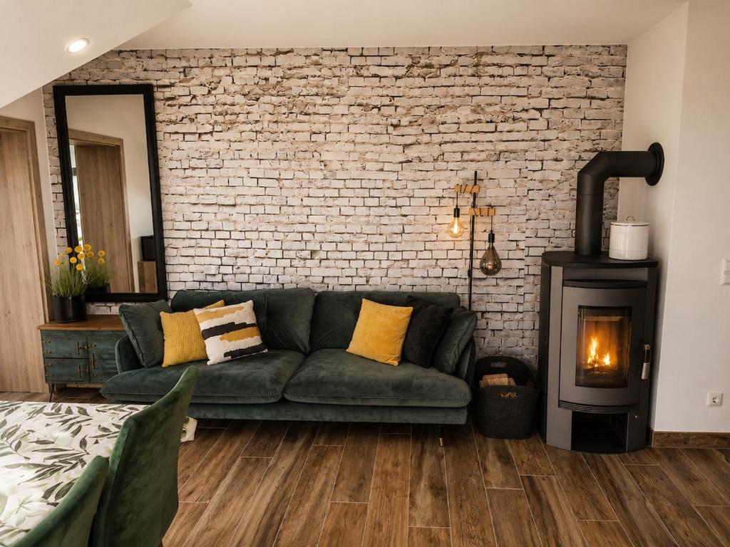 a living room with a green couch and a fireplace at Modern apartment with balcony & panoramic view in Tirschenreuth