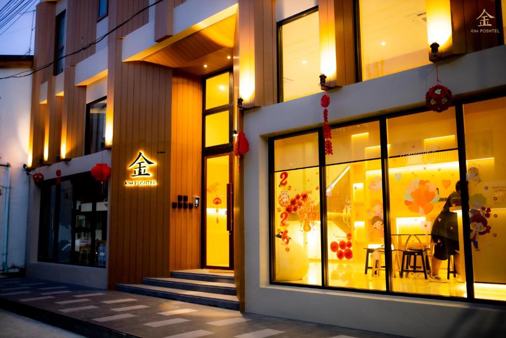 a store front of a building at night at Kim Poshtel Hatyai in Hat Yai