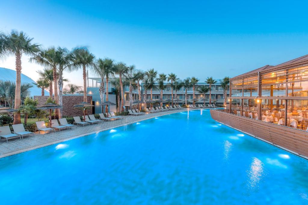 a swimming pool at a resort with palm trees at Blue Lagoon Resort in Lampi