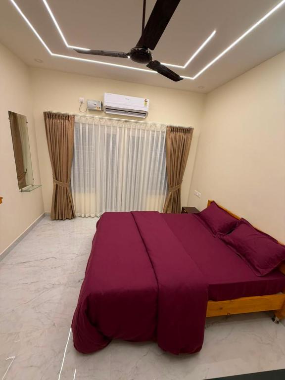 a bedroom with a large purple bed in a room at Seabreeze Village Resort and Restaurant in Gokarn