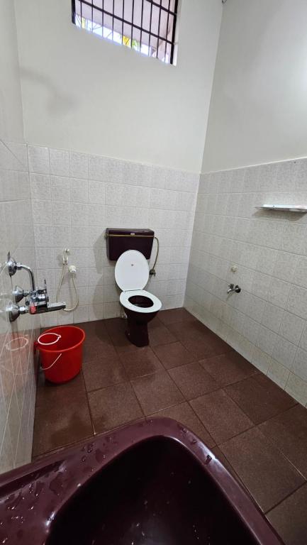 a bathroom with a toilet and a bath tub at Marwa in Kannur
