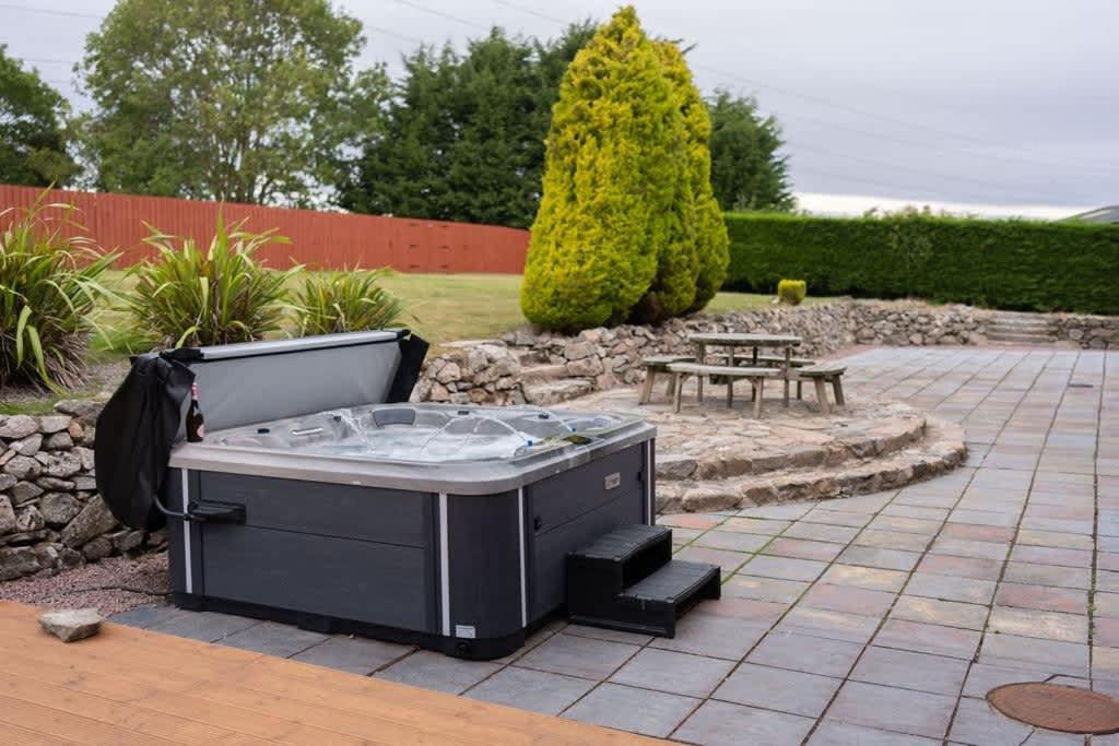 a hot tub in the middle of a patio at Woodside Barn in Newmacher