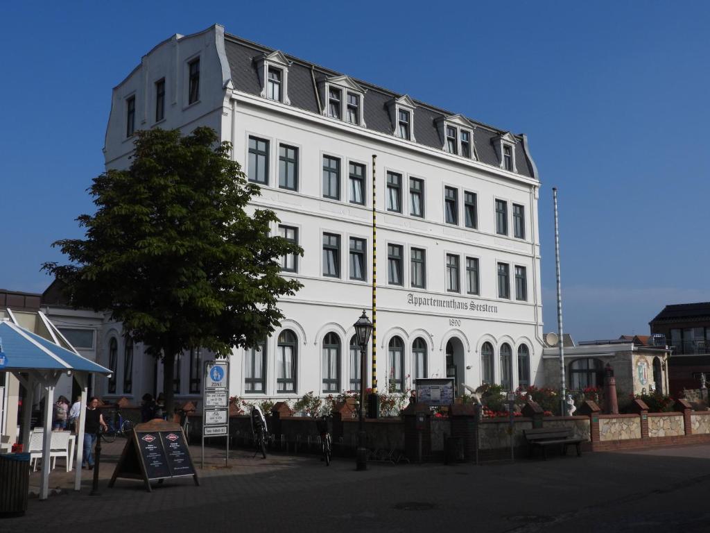 a large white building on the side of a street at Appartementhaus Seestern in Borkum