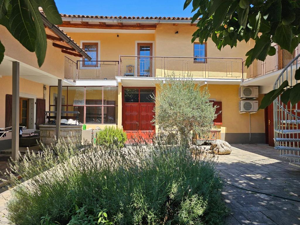 a house with a red door in a yard at Kraska nisa in Komen