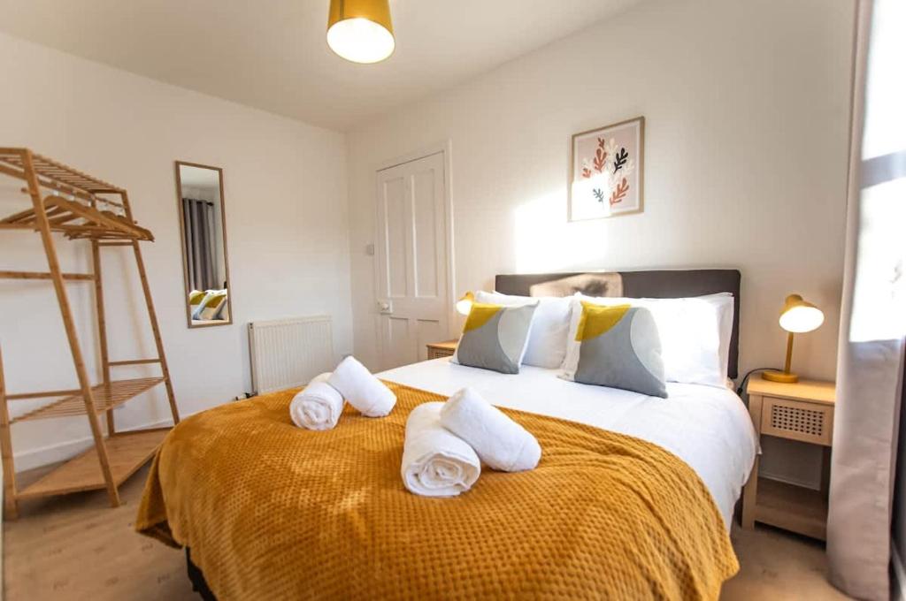 a bedroom with a large bed with towels on it at Beach House in Thurso