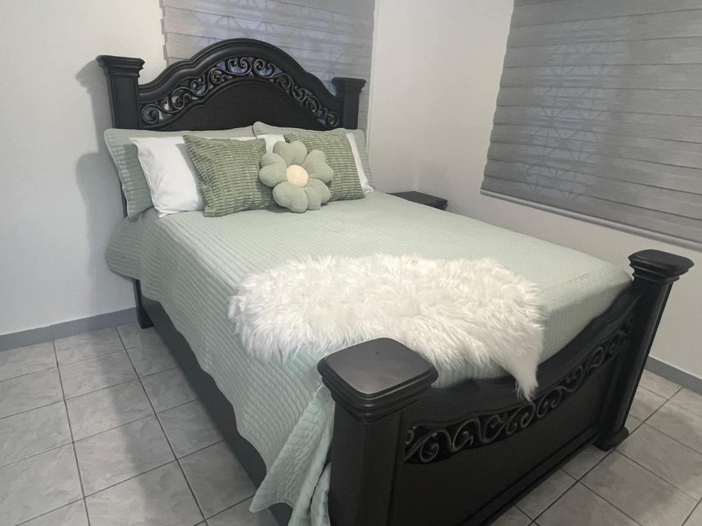 a bedroom with a bed with a teddy bear on it at Angels in Spanish Town