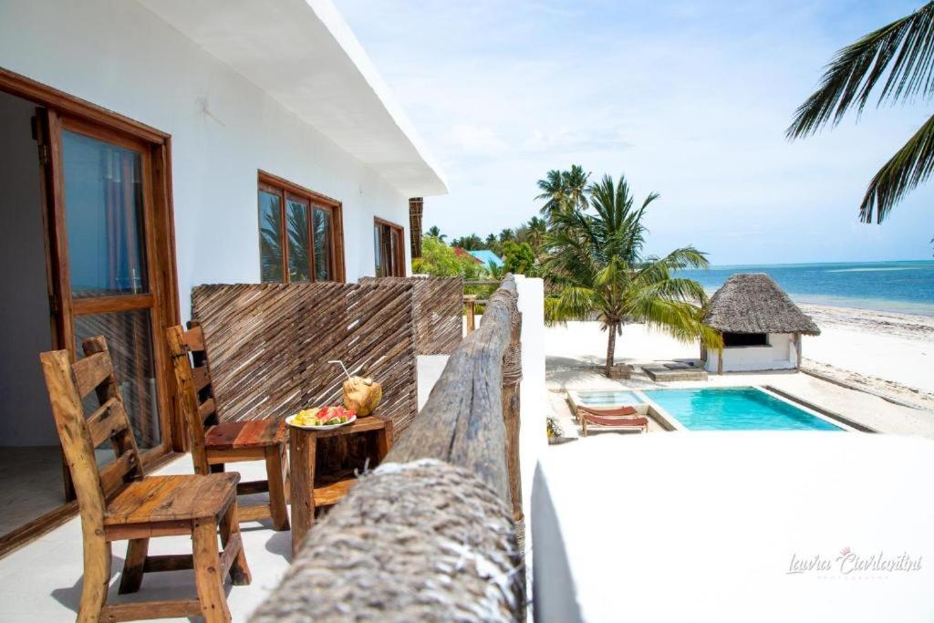 Eine Villa mit Blick auf den Strand und einen Swimmingpool in der Unterkunft Moonshine Uroa Boutique Hotel in Uroa