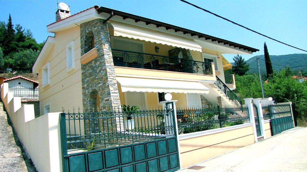 a large house with a fence and a balcony at Forest view apartment in Zigós