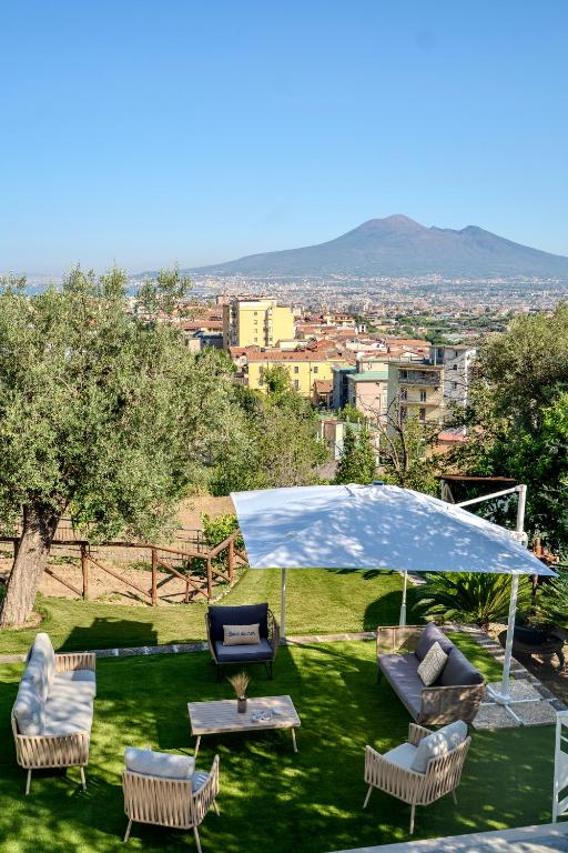 a group of chairs and a table with a blue umbrella at Grania Le Radici - Agriresort in Gragnano