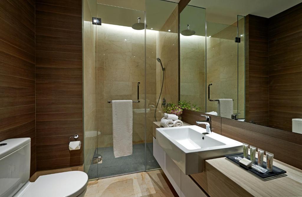 A compact marble-look bathroom with a glass-enclosed shower and vanity.