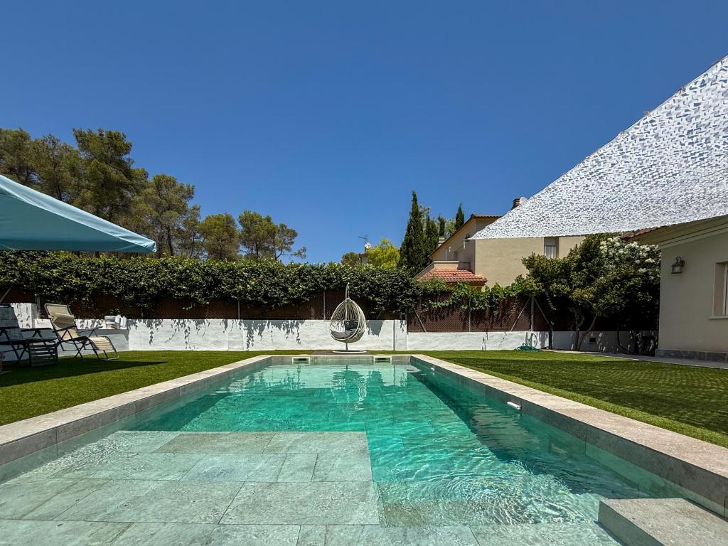 a swimming pool in the backyard of a house at Villa Claudia by Hello Homes Sitges in Sitges