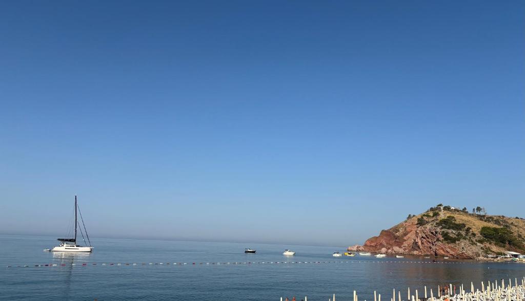 a sailboat floating in the water next to an island at Lola Sutomore in Sutomore