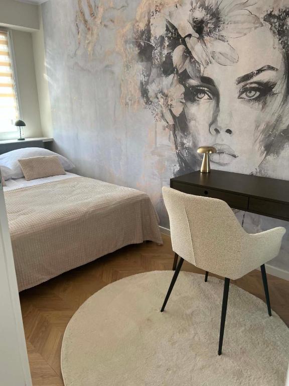 a bedroom with a bed and a desk and a chair at Modern Apartament Zakole in Konin