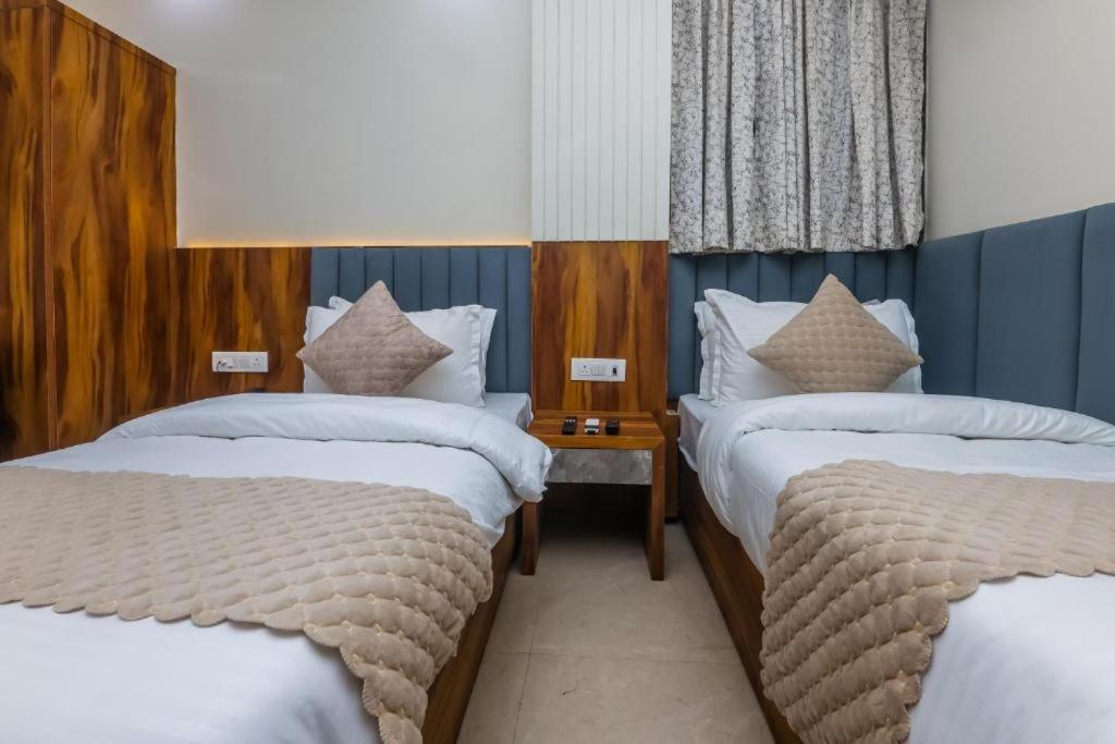a hotel room with two beds and a table at Hotel Shivkashi Palace By G K Group in Varanasi
