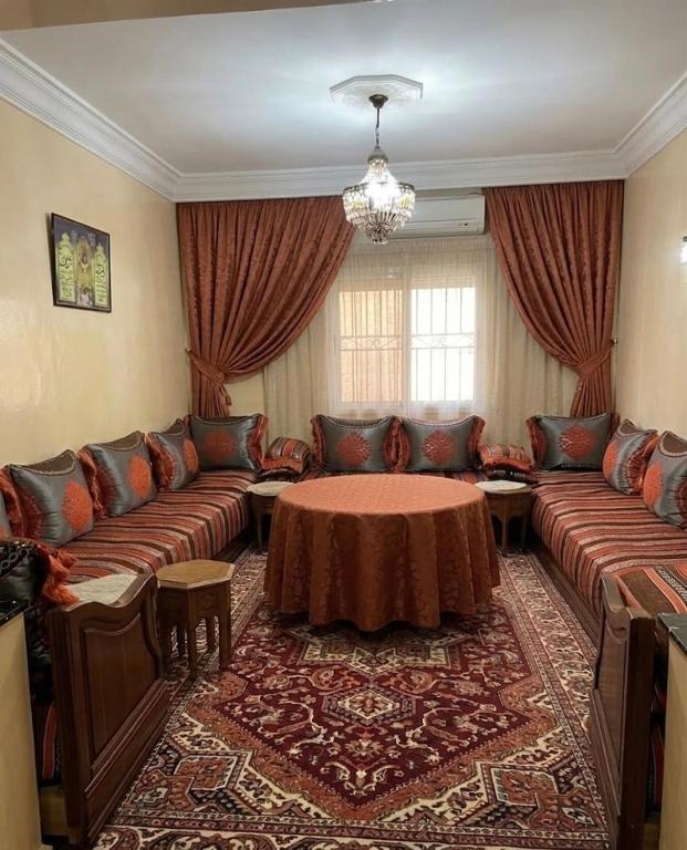 a living room with a couch and a table at مراكش تامنصورت in Aït Ali