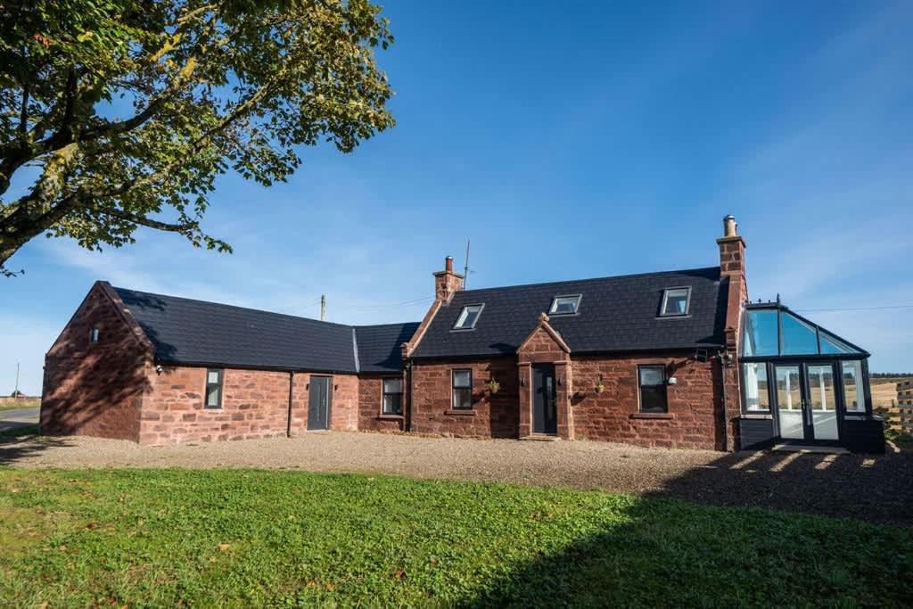 a brick house with a black roof at Easter Cottage -4 Bed Converted Barn Cottage in Turriff