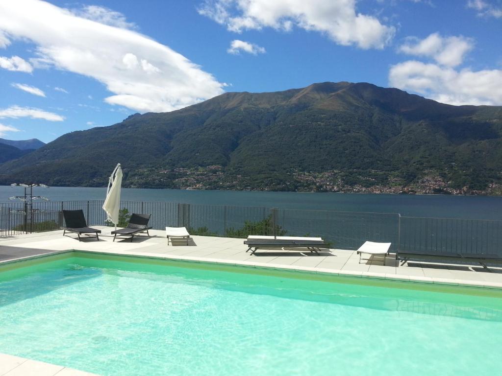 a swimming pool with chairs and a view of a mountain at Residence Il Poggio in Dorio