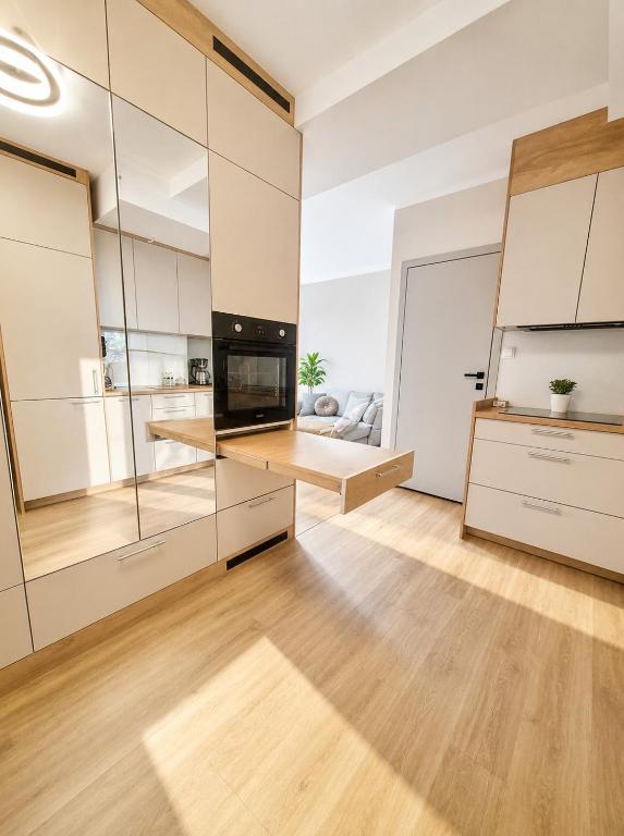 a kitchen with white cabinets and a large glass wall at Kaszmirowy Apartament in Wałcz