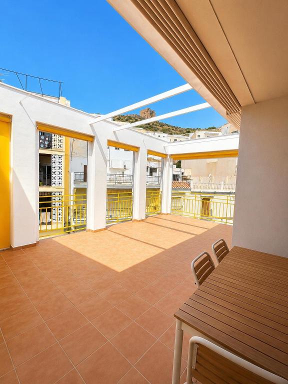 a balcony with a table and chairs on a building at Casa Soleá- a dos min de la playa in Castell de Ferro