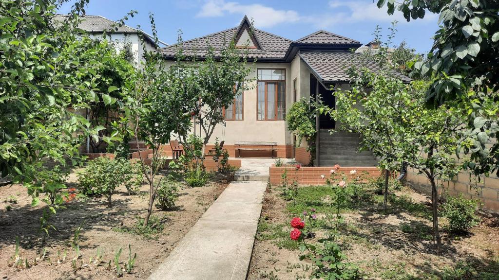 a garden in front of a house with trees at Halal House Vip in Qusar