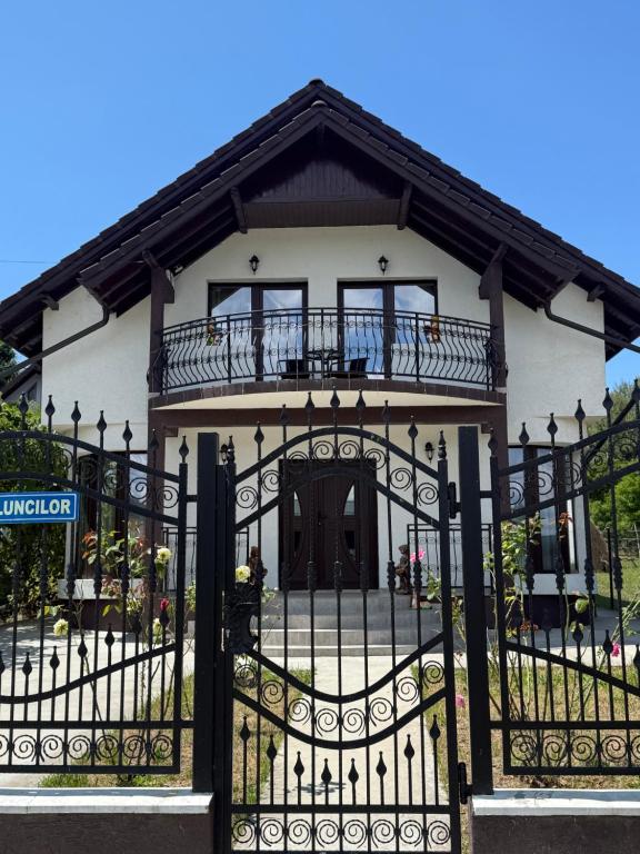 a house with a black gate with a balcony at Vila MaeStar in Curtea de Argeş