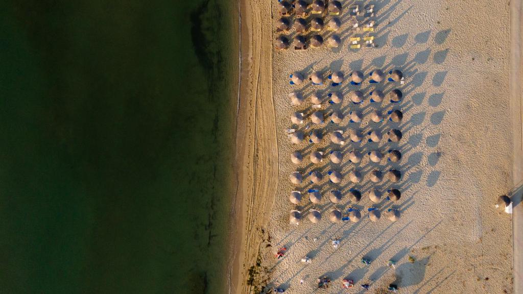 an aerial view of a beach with a bunch of umbrellas at OLYMPIADA GIRNI Suites in Paralia Katerinis