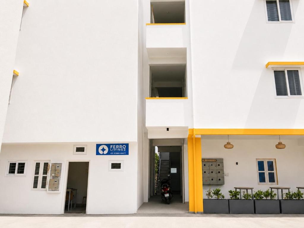 a white building with a motorcycle parked in it at Hotel Ferro in Kumbalgod