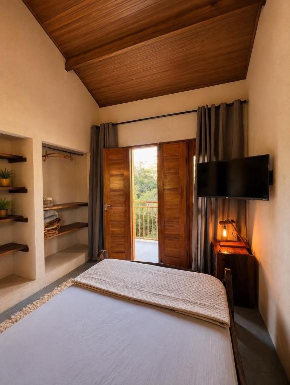 a bedroom with a large bed and a window at Reserva do Bosque Hospedaria e Natureza in Ibicoara