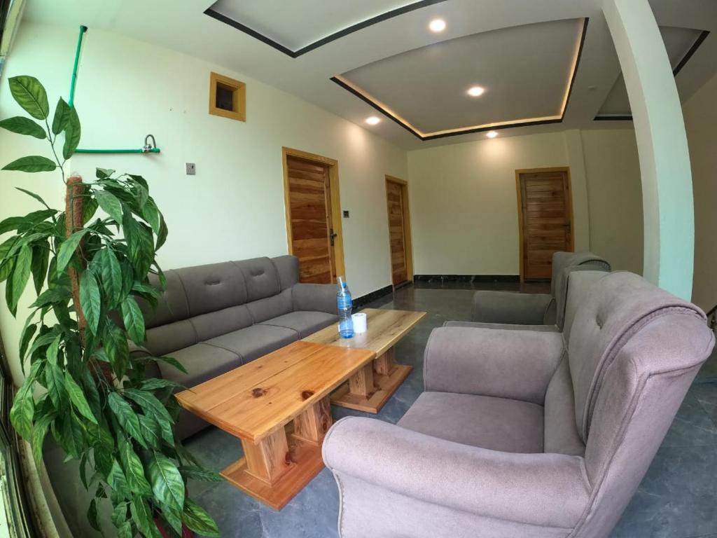 a living room with couches and a wooden table at Snow Land Hotel and Restaurant in Malam Jabba