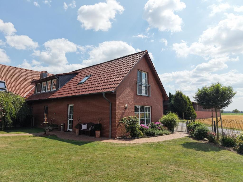 a red brick house with a grass yard at Ferienhof Michaelis in Bruchhausen-Vilsen