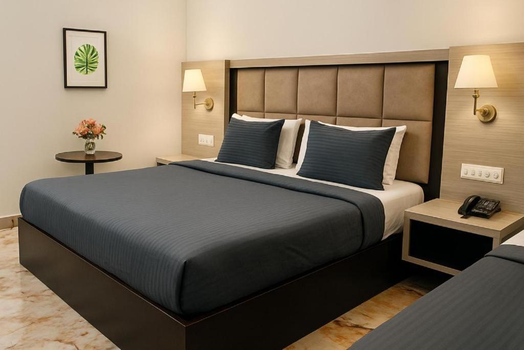 a bedroom with a large bed with blue pillows at Hotel Prime Fine in Agra