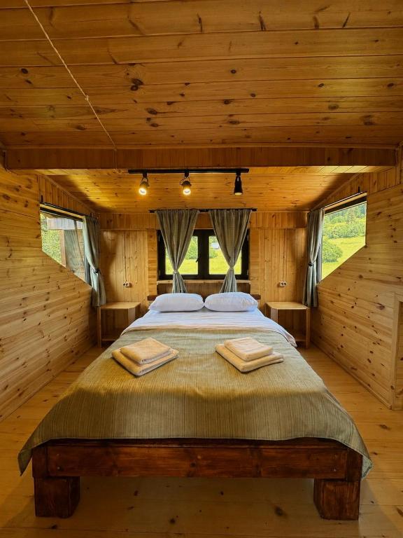 a bedroom with a large bed in a log cabin at Chalet Hatsvali - Ushba Viewpoint Rooms & Café in Mestia