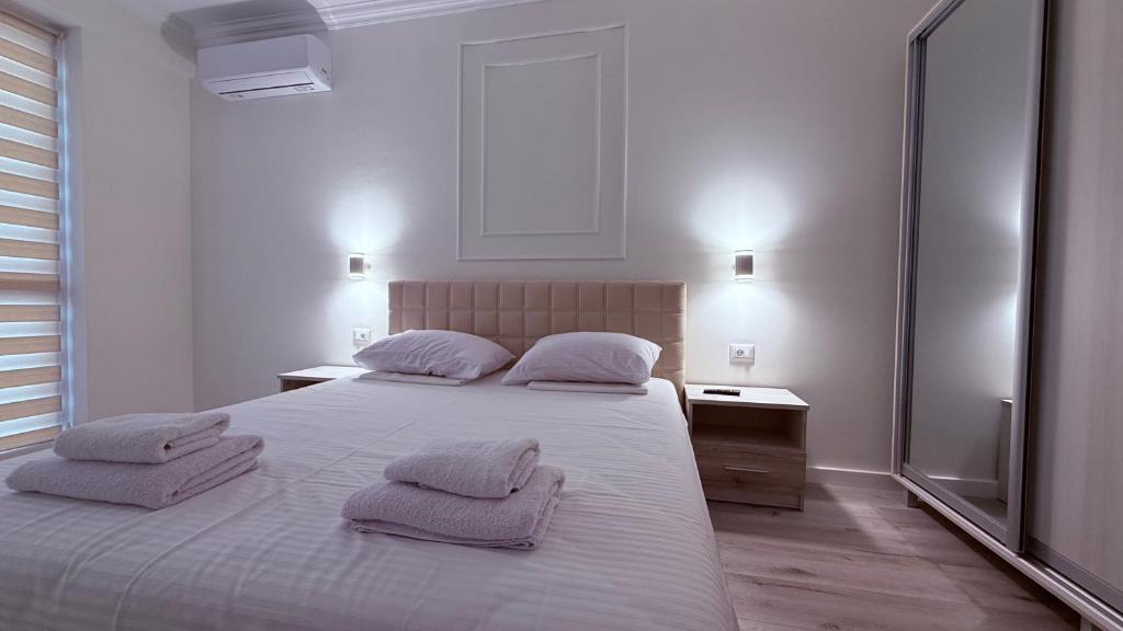a white bedroom with two pillows on a bed at Apartment OneClickRent 16 in Chişinău