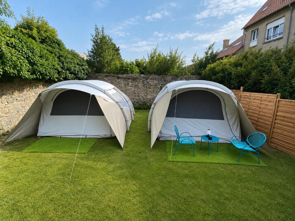 two tents in a yard with two chairs and a table at Glamping - accès JACUZZI et SAUNA in Boulogne-sur-Mer