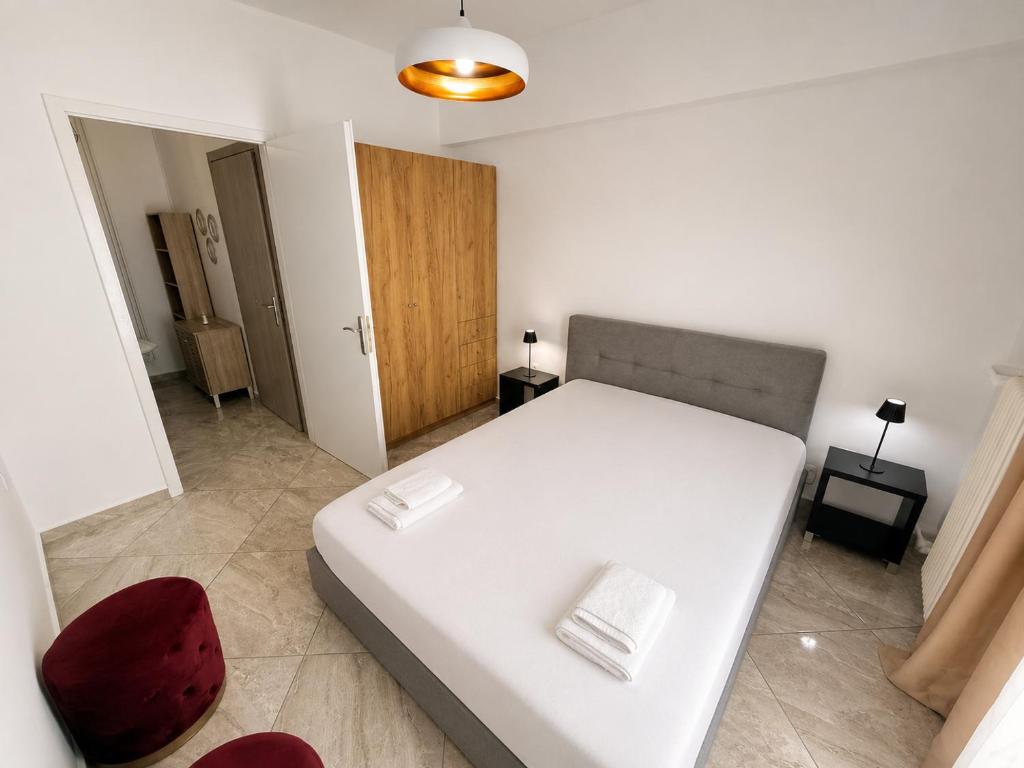 a bedroom with a white bed and a red chair at Central Park Chíos in Chios
