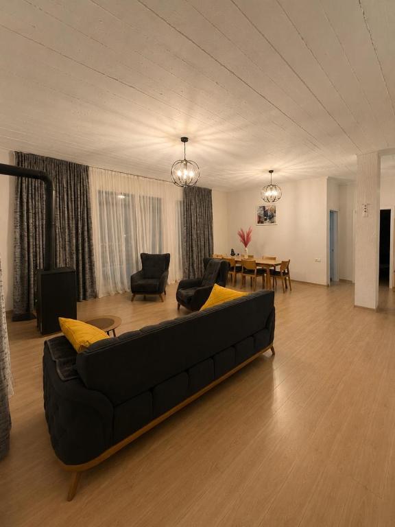 a living room with a black couch and a table at Apartment MILU in Mestia