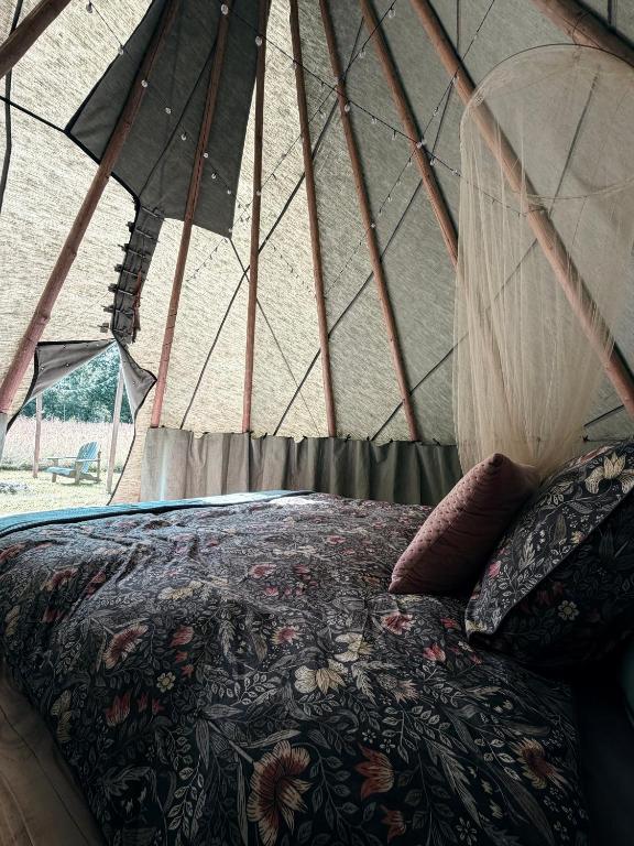 a bedroom with a bed in a tent at Zariņmājas Mistērija in Ceļarāji
