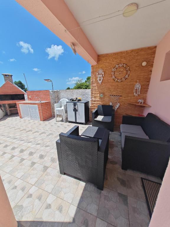 a patio with couches and tables and a clock at Eiras AL Ilha da Madeira in Santa Cruz