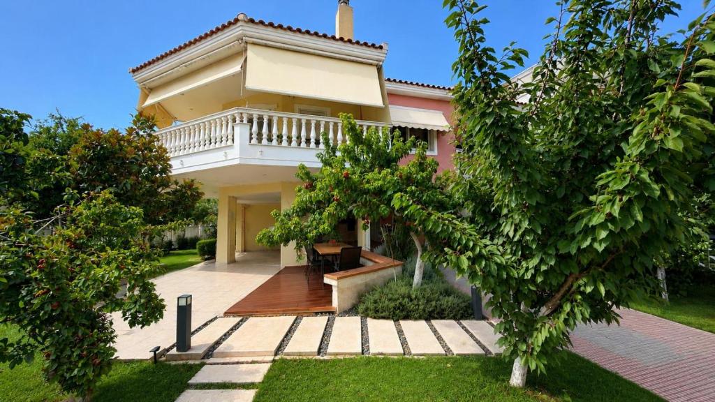 a house with a balcony on the front of it at Garden Bliss Alexandroupolis in Alexandroupoli